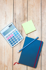 CALCULATOR WITH DIARY AND SCREEN SHEETS ON WOODEN TABLE