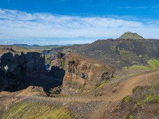 View on majestic Markarfljotsgljufur Canyon gorge and river with green hills and Hattafell mountain near Botnar camp at Fjallabak Nature Reserve in Highlands of Iceland, blue sky background