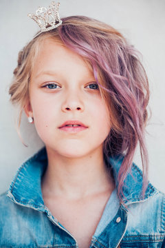 Portrait of 8 years old russian girl with colored hair wearing headband with crown.