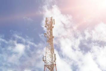 Silhouette of the top of a communication tower against a cloudy sky. Sun Rays and Mobile Transmitter