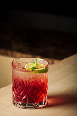 Pink and red Fresh colorful exotic alcoholic cocktail with lemon and ice in the bar. Colorful pink Soft drink with ice on the bar desk. Red colorful Mojito