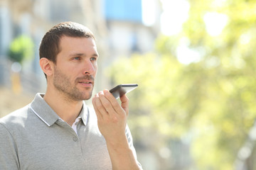 Man using voice recognition on phone in the street
