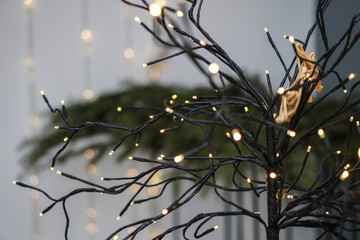 Beautiful yellow garlands in an interesting composition on the background of a Christmas tree. New Year theme for design
