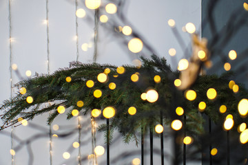 Beautiful yellow garlands in an interesting composition on the background of a Christmas tree. New Year theme for design