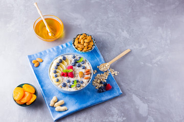 Healthy homemade oatmeal with berries and nuts for breakfast. Oatmeal with fruits, nuts and honey. Oatmeal with blueberries, banana and raspberries
