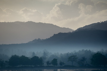 The trees and mountains of Lombok, Indonesia are shrouded in mist right before sunrise