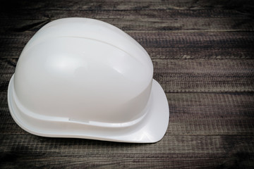 Fototapeta premium Helmet on dark wooden table. Security. The concept of hygiene and safety at work, home. Head care, protection against injury.