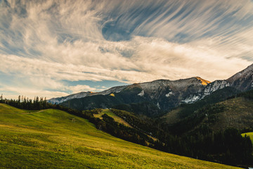High rocky mountains against the background of the setting sun. Zdiar in Slovakia, high Bielanske Tatras. Trip to the mountains, climbing, hiking in the mountains. Tourists in the mountains.