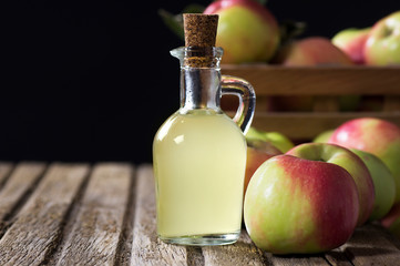 Glass bottle of handmade organic apple cider vinegar made from fermented fresh ripe apples. Healthy organic food, selective focus, space for text