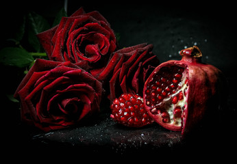 red roses with pomegranate on a black background