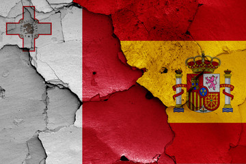 flags of Malta and Spain painted on cracked wall