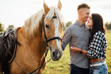 Fototapeta premium Portrait of happy loving couple spending time with horses on ranch