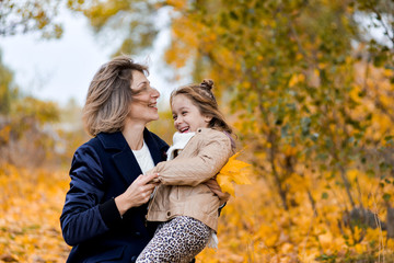 mother and daughter in autumn park have fun