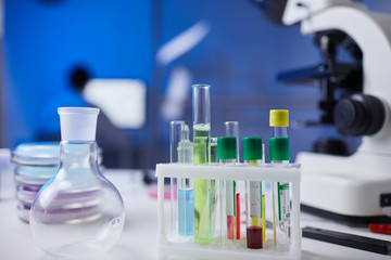 Close up of assorted glassware and test tubes with blood samples on table in medical laboratory, copy space