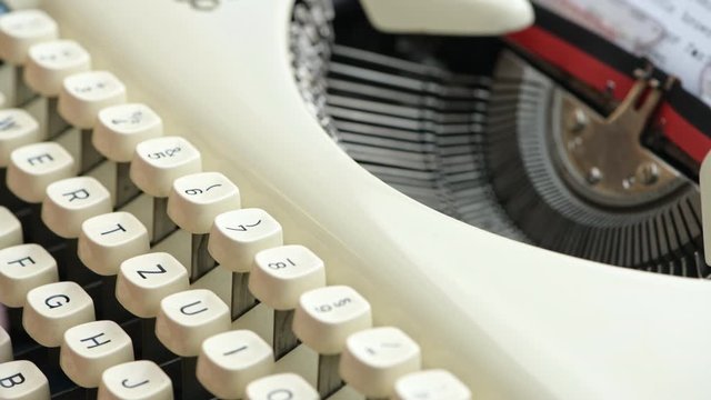 Close up of a 1950's era German typewriter keyboard.  Keys are QWERTZ instead of QWERTY.  Fingers typing.
