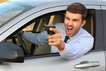 Stressed male driver yelling and holding a gun