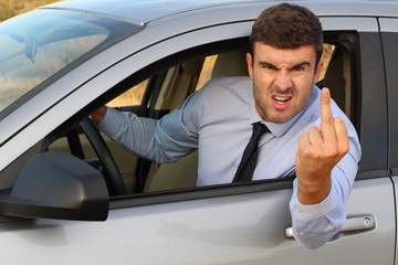 Angry businessman showing middle finger while driving