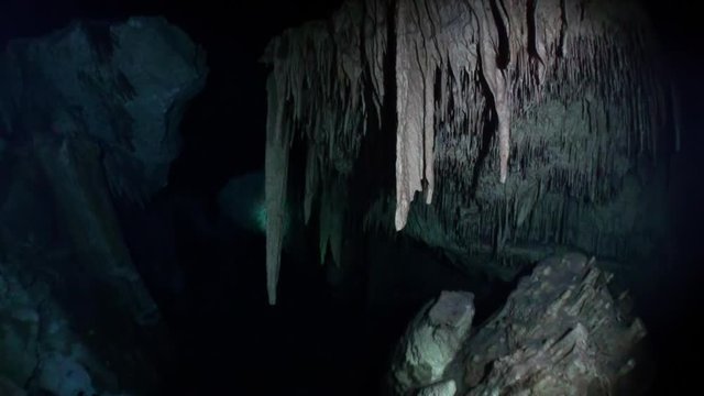 Stalactite stone icicles hang from ceiling of cave in underwater Yucatan Mexico cenotes. Clean and clear underground water.