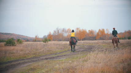 Obraz premium Two women are riding ginger horses on the autumn field