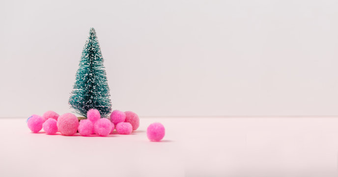 Miniature Christmas tree and  snow pink balls decoration. Holiday minimal conept