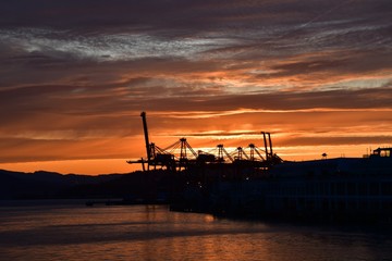 Fototapeta na wymiar A picture of the silhouette of Metro Vaancouver's port against the sunrise. Vancouver BC Canada