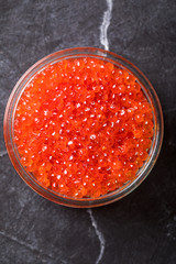 Salmon  Red Caviar in a white plate on a dark background. Healthy Food Concept. Snack.Copy space for Text.Seafood.
