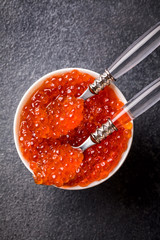 Salmon  Red Caviar in a white plate on a dark background. Healthy Food Concept. Snack.Seafood.