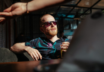 Man in sunglasses drinks lemonade and awaits his lunch