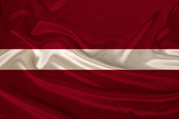 photo of the national flag of Latvia on a luxurious texture of satin, silk with waves, folds and highlights, close-up, copy space, concept of travel, economy and state policy, illustration
