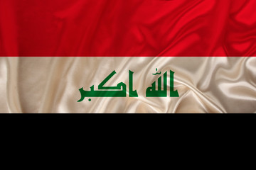 beautiful photo of the colored national flag of the modern state of Iraq on textural fabric, concept of tourism, emigration, economy and politics, close up