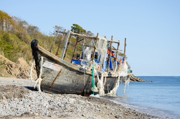 Old abandoned fishing schooner on the seashore.