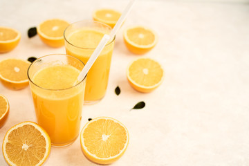 freshly squeezed orange juice in glasses on the kitchen table with slices of oranges, concept of diet and healthy lifestyle