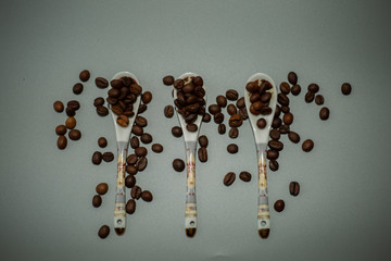 spilled coffee beans on three spoons