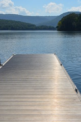 Obraz premium A dock over a lake with mountains in the background.