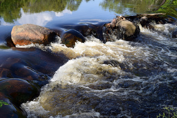 Large boulders in a river causing waterfalls.