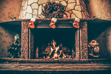 Warm cozy fireplace decorated for Christmas with real wood burning in it. Cozy Christmas concept....