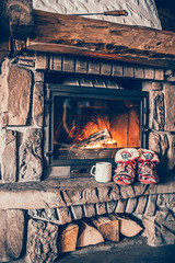 Christmas comfortable slippers by the warm cozy fireplace. Relaxing atmosphere in a chalet by...