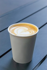 The cup of coffee on the wooden table