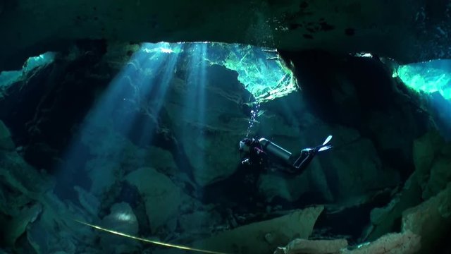 Divers in cave of underwater Yucatan Mexico cenotes. Divers in cave of underwater cenotes. Dangerous extreme diving in clean and clear water. Cave diving in underground water.