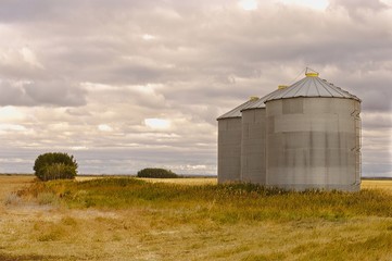 Grain silos sitting on a field