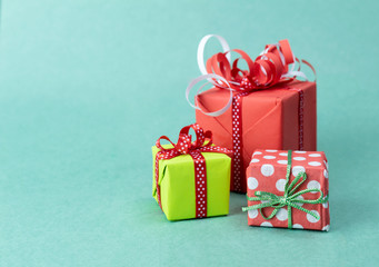 Gift boxes in bright wrapping paper on a green background.