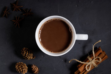White ceramic cups of hot cocoa with marshmallows on top of rustic black background