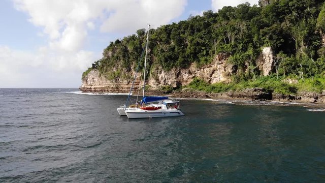 Catamaran yacht anchored in a sheltered bay on an island to avoid the storm