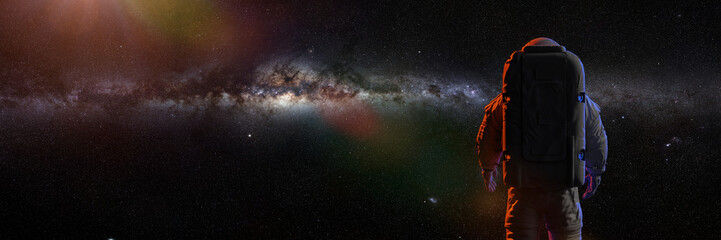 astronaute debout devant la magnifique galaxie de la Voie lactée
