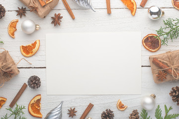 Christmas frame. Postcard with Christmas tree branch and gifts, on white wooden background.