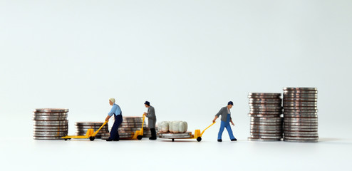 Miniature people pulling stack coins using for logistic.