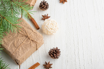 Flat lay.Christmas composition, snow-covered branches of a Christmas tree. Cones. Gifts. Atmosphere. New Year and holiday. On a white wooden background.