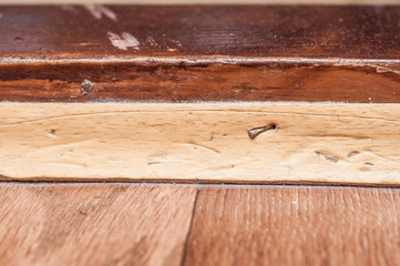 The baseboard is nailed to the threshold. Home repair.