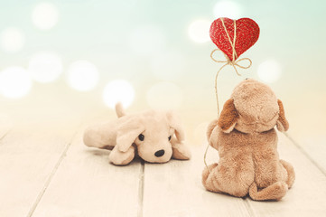 Valentines Day holiday background with toy dogs. Plush dog declares his love holding a red heart on...
