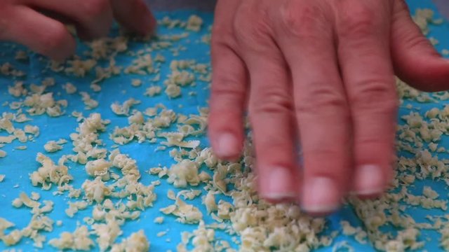 Making a bee wrap, zero waste solution replacing plastic wrap, made from beeswax and blue textile. Closeup on woman's hand. Spread on baking sheet. Healthy & organic lifestyle. Holiday kids activity. 